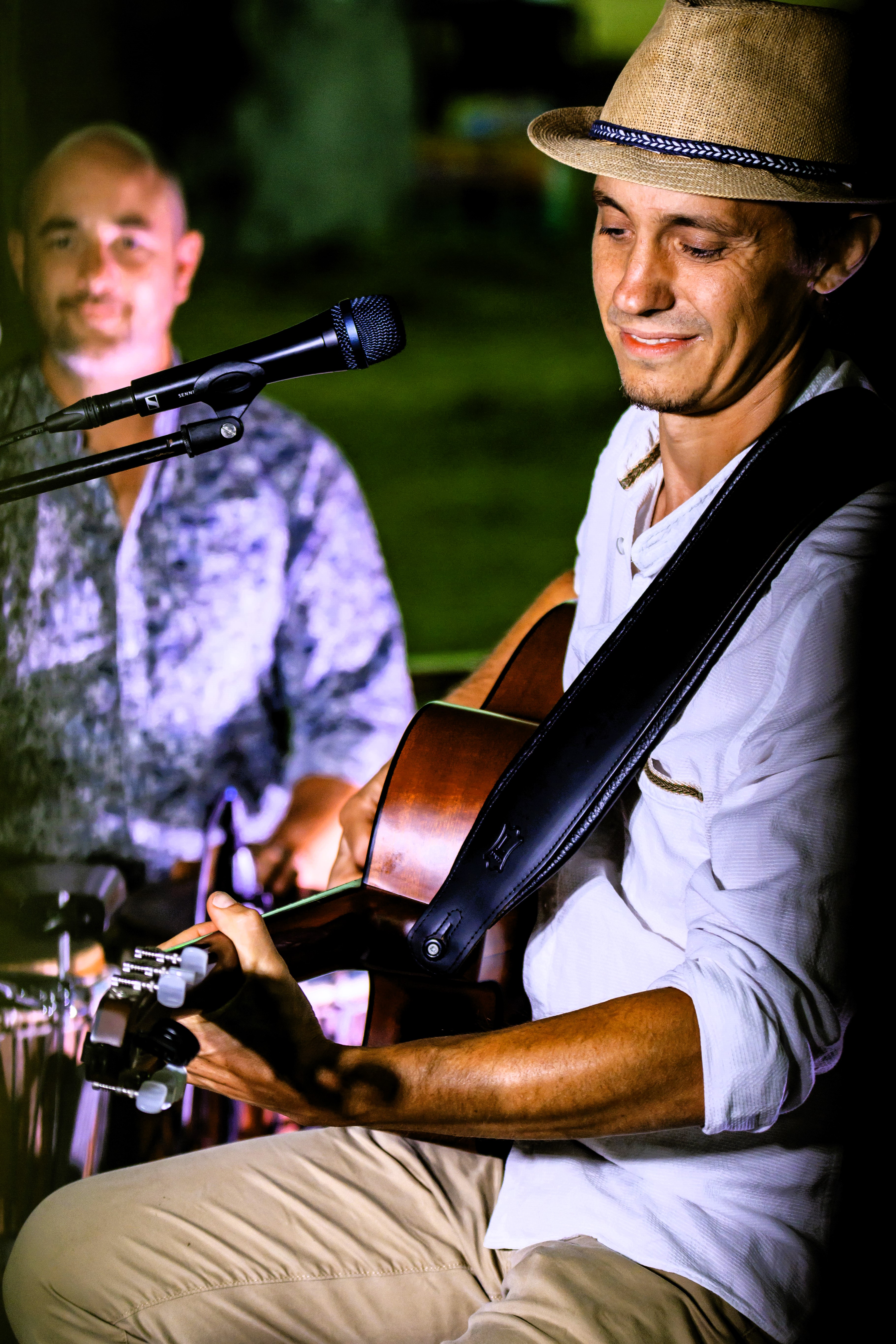 Un guitariste au premier plan et un percussionniste au second plan